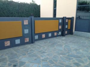 una valla con pintura amarilla y azul en un patio en Caprice, en Avigliana