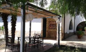 eine Terrasse mit Tisch und Stühlen unter einer Pergola in der Unterkunft Casa Masseria Le Ville in Peschici + 42 Fotos