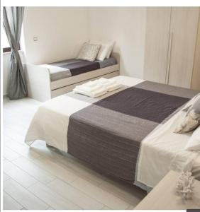 アグローポリにあるB&B DAFNEのベッド2台とソファがあるホテルの部屋