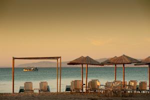 un gruppo di sedie e ombrelloni in spiaggia di Hotel Pithari a Agia Triada