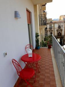 a small red table and chairs on a balcony at 5 cupole in Palermo