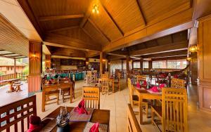 an empty restaurant with wooden tables and chairs at Andamanee Boutique Resort Aonang Krabi - Free Beach Shuttle - SHA Extra Plus in Ao Nang Beach