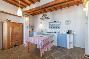 a kitchen with blue and white cabinets and a table at Sylvia House in Arnados