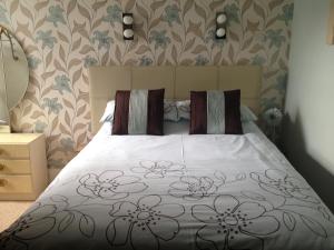 sypialnia z łóżkiem i wzorzystą ścianą kwiatową w obiekcie Bluebell Hotel w Blackpool