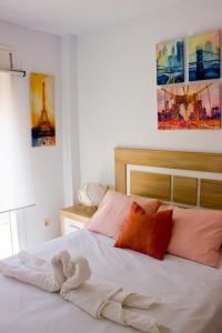 sypialnia z białym łóżkiem z pomarańczowymi poduszkami w obiekcie Seaview Fuengirola Apartment by JITKey w mieście Fuengirola