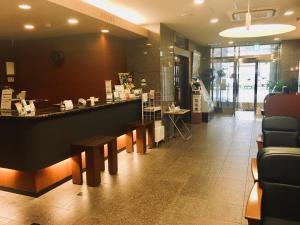 a restaurant with a counter and benches in a lobby at Hotel Route-Inn Fukaya Ekimae in Fukaya