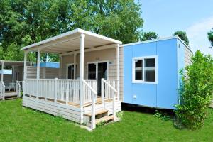 a tiny house with a porch and a blue house at Camping Bella Italia in Peschiera del Garda