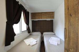 two beds in a small room with a window at Camping Bella Italia in Peschiera del Garda