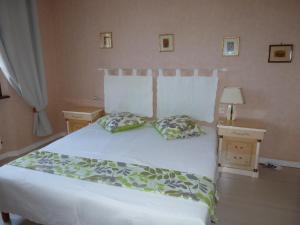 a bedroom with a white bed with two pillows at entre mer et verdon in Draguignan