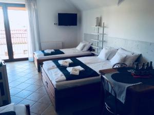 a hotel room with two beds and a television at Malinowe Lato in Grzybowo