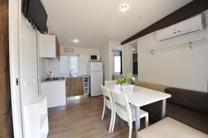 a kitchen and dining room with a white table and chairs at Camping Bella Italia in Peschiera del Garda