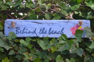 una señal con las palabras detrás de la tierra en Behind the Beach, en Zandvoort