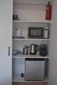 a microwave oven sitting on a shelf in a kitchen at Behind the Beach in Zandvoort