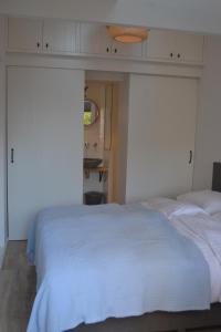 a bedroom with a white bed and a mirror at Behind the Beach in Zandvoort