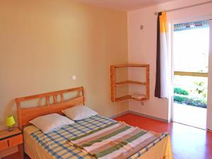 um quarto com uma cama e uma grande janela em GITE-Hotel LA CAZ DES ORANGERS em Le Bois de Nèfles