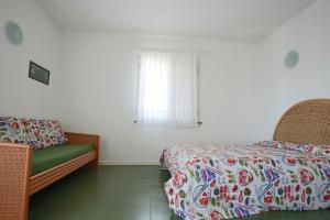 een slaapkamer met een bed, een bank en een raam bij Residence Selenis in Caorle +22 foto's