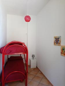 a red chair in a corner of a room at Apartment of kite and wine in Birgi Vecchi