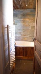 a bathroom with a tub and a sink and a door at Appartement du Petit Bois in Megève +10 photos