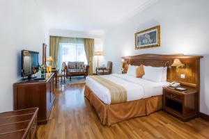 a hotel room with a bed and a television at Grand Excelsior Hotel - Bur Dubai in Dubai