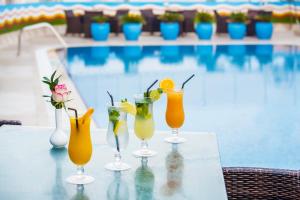 a group of cocktails sitting on a table next to a pool at Grand Excelsior Hotel - Bur Dubai in Dubai