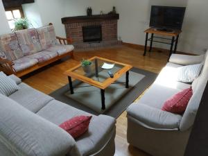 Sala de estar con 2 sofás y mesa de centro en La Posada Nueva, en Viscarret-Guerendiáin