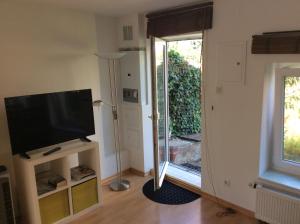 een woonkamer met een flatscreen-tv en een raam bij Altstadt Bonn mit eigenem Parkplatz und Garten in Bonn