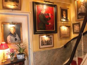 a hallway with portraits on the wall and a stairway with paintings at Park Mansion Centre in Amsterdam