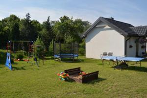 a yard with some playground equipment in the grass at Domki "Bociania Ostoja" in Mikołajki