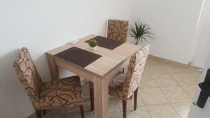 a wooden table with two chairs and a plant at Apartments Ponta in Kotor