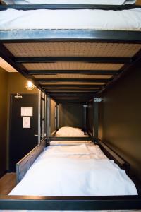 1 cama en una habitación pequeña con una estratificación de avertisementatronatronatronstracionstrationstrationstrationstrationstrationstrationstrationstration en Amsterdam Hostel Orfeo, en Ámsterdam