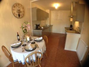 a dining room with a table with a clock on the wall at Boutique Appartement 2 Chambres dans le Vieux Cahors in Cahors