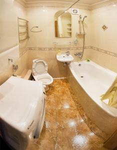 a bathroom with a tub and a toilet and a sink at Poltava Green Apartments in Poltava +8 photos