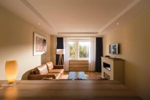 ein Wohnzimmer mit einer Couch und einem Fenster in der Unterkunft Baltic Zinnowitz - Hotel mit Meerwasserpool und Thermalbad in Zinnowitz