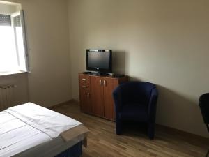 a bedroom with a bed and a tv and a chair at Apartmaji Zonta in Koper