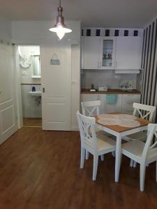 a kitchen with a white table and chairs and a kitchen with a table at Tri Gracije in Koper