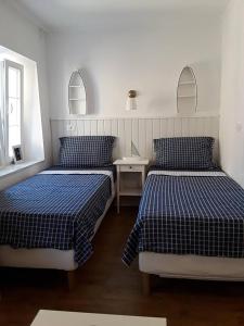 a bedroom with two beds and a table and two mirrors at Tri Gracije in Koper