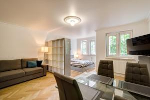 a living room with a glass table and a couch at Dom & House - Apartments Ogrodowa Sopot in Sopot