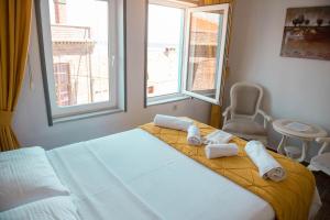 A bed or beds in a room at Bozcaada Aspava Otel