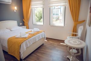 A bed or beds in a room at Bozcaada Aspava Otel