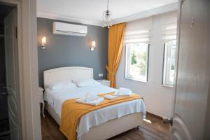 A bed or beds in a room at Bozcaada Aspava Otel
