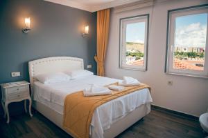 A bed or beds in a room at Bozcaada Aspava Otel