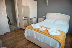 A bed or beds in a room at Bozcaada Aspava Otel