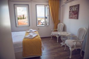 A bed or beds in a room at Bozcaada Aspava Otel