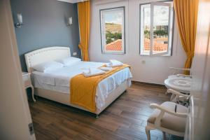 A bed or beds in a room at Bozcaada Aspava Otel