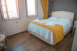 A bed or beds in a room at Bozcaada Aspava Otel
