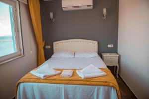 A bed or beds in a room at Bozcaada Aspava Otel
