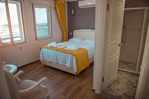 A bed or beds in a room at Bozcaada Aspava Otel
