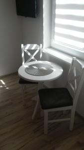 ブワディスワボボにあるPokoje Goscinne Lucjaの白いテーブルと椅子、窓