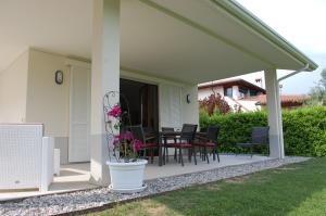 un patio con sillas y una mesa con flores en Villa Sophora, en Moniga del Garda