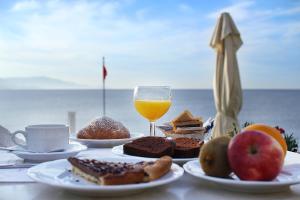 a table with plates of food and a glass of orange juice at Hotel Punta Negra in Alghero